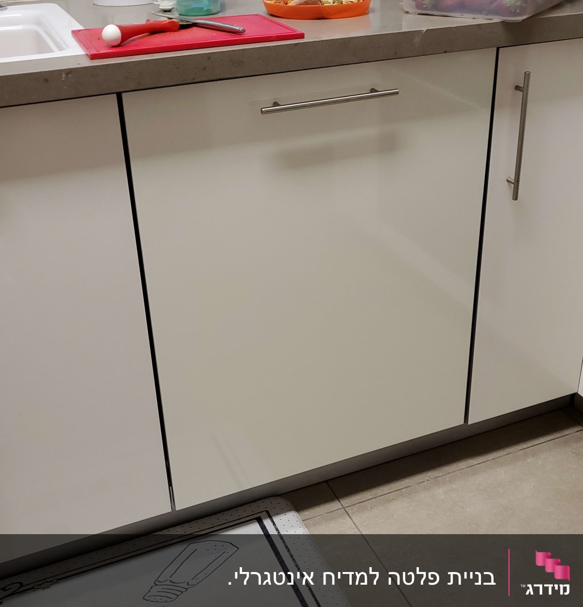 מטבח עם כלים על השיש, קרש חיתוך וסכין